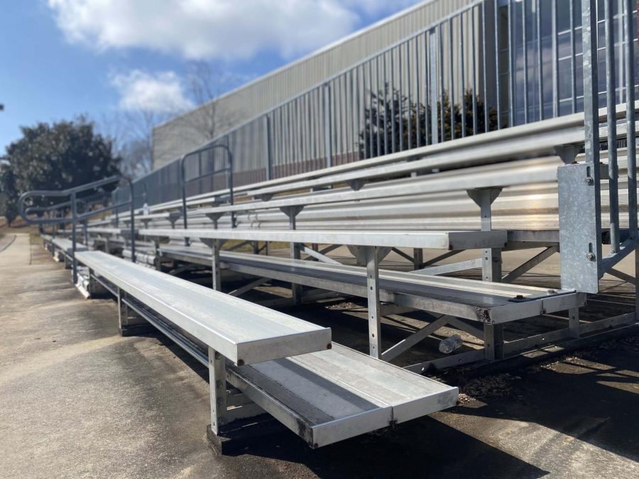 The bleachers sit empty even as athletes return to the field.