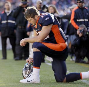 Tim Tebow kneels during a Bronco football game, in an effort to represent his faith. PHOTO // bostonglobe.com