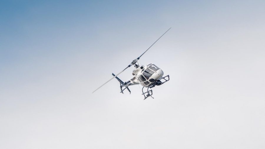 A helicopter flies high above Stewart Hall.