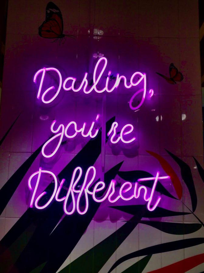 Purple neon sign reading Darling, youre different