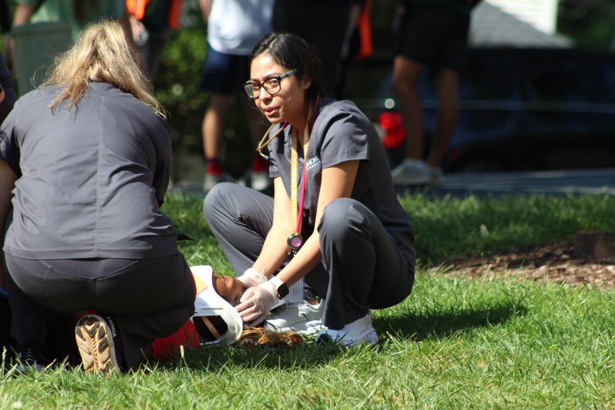 Nursing students secure the head of a patient.