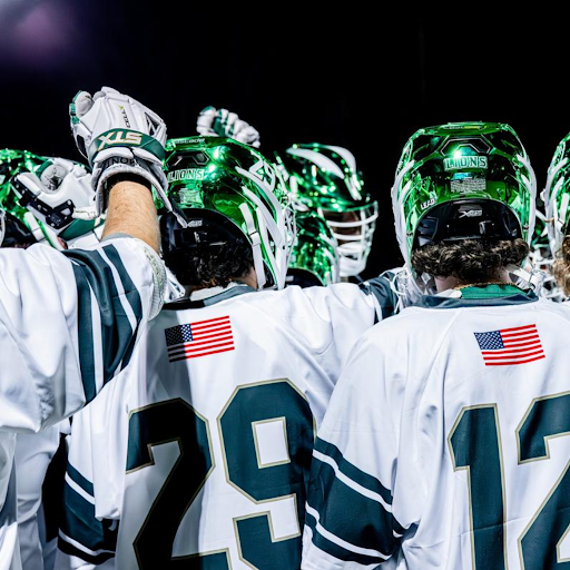 Piedmont men’s lacrosse huddle as a team in their new green helmets.