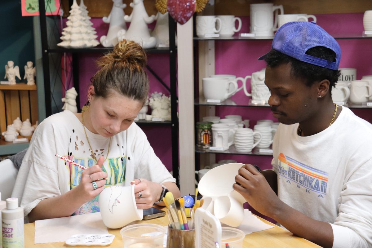 Students Maggie Bishop and Draylon Starks begin to decorate their pottery. Once finished, the studio will fire the work in their kiln, creating a permanent memory.