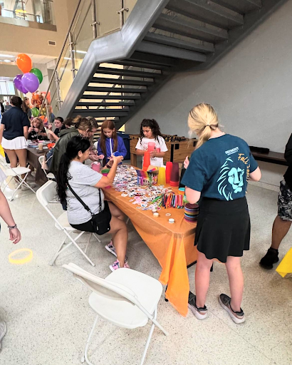 Kids, parents and students decorating cups.