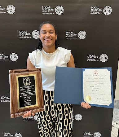 Chloe Spradlin holding The Roar’s awards from the Georgia College Press Association. 