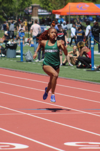 With her red hair trailing like a flame, Michelle Cates blazes down the track toward the finish line.