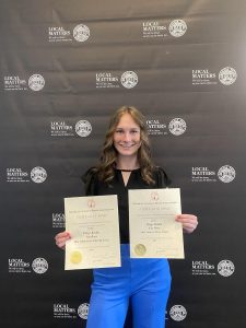 Editor-in-Chief Paige Kluba holding awards from the Georgia College Press Association. 