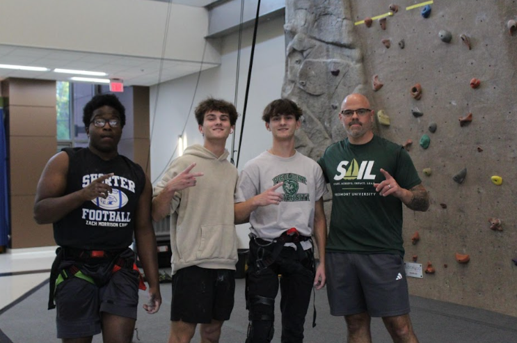Students Livingston Jenkins (left), Jackson Parker, Nicholas Parker, and Jason Croy (right) work on encouraging students to participate in climbing the rock wall to build teamwork and spread positivity. 