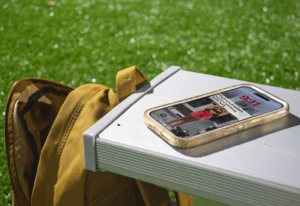 Portrait of a student's bookbag and phone with a reminder for a class that takes place at 9:11 A.M.