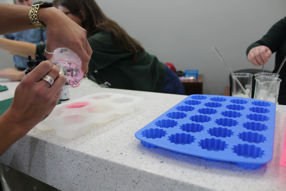 Christina Sierra carefully pours her freshly made soap mixture into a mold during the Global Handwashing Day event. Students were guided through the soap-making process to better understand the importance of handwashing and how soap works to remove germs.